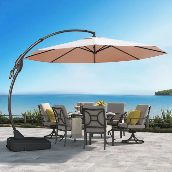 The 12 FT Napoli Sunbrella cantilever umbrella with a tan canopy seen from below, ribs showing, over a six-seat dining set with grey cushions on a seaside terrace