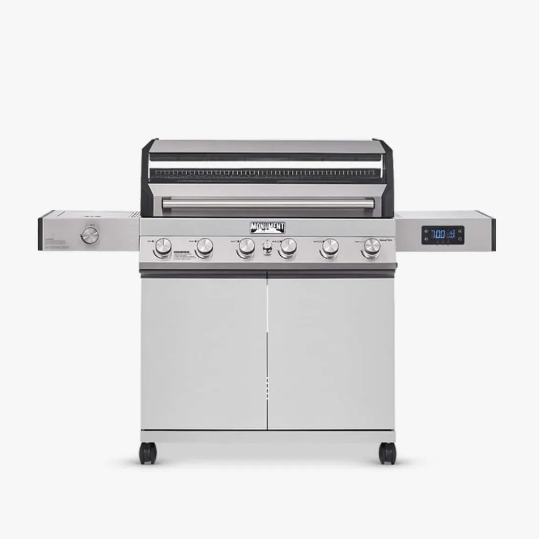 A stainless Monument Denali 605 gas grill photographed straight on against a plain light background, lid closed, the digital display on the right shelf and two cabinet doors below