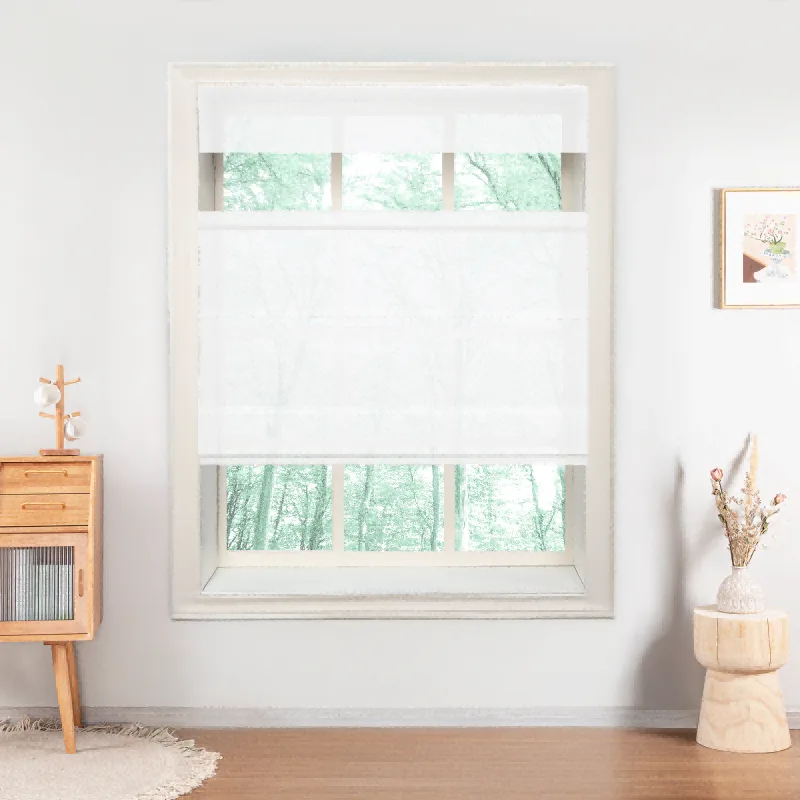 A white top down bottom up roman shade on a tall window, glass showing above and below the fabric, a wooden cabinet and a stool beside it