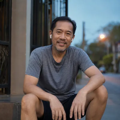 A man in his forties on a doorstep in running gear at first light