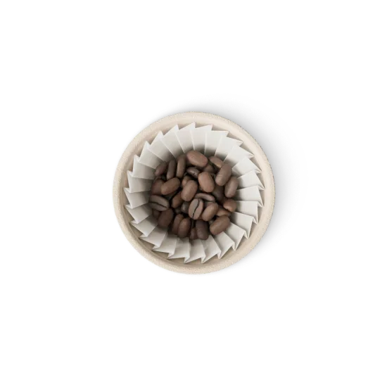 An open xPod seen from above: whole roasted coffee beans resting in the pleated paper filter inside the cream sugarcane fiber pod